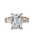 The 18K Rose Gold 3-Stone Baguette East/West Side Stones 0.25TCW Engagement Ring features a large emerald-cut center stone with two smaller baguette side stones in a prong setting, shown against a white background.