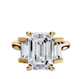 The 18K Yellow Gold 3-Stone Baguette Side Stones Set North/South 0.25TCW Engagement Ring showcases a large center diamond with baguette-cut side stones on a clean, plain background.