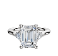 An 18K white gold engagement ring featuring a large center stone and two trillion side diamonds (0.125TCW), displayed on a plain white background.