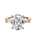The 18K Rose Gold 3-Stone Baguette East/West Side Stones 0.125TCW Engagement Ring features an oval center diamond flanked by two horizontally set baguette side stones on a rose gold band.