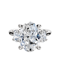 The 18K White Gold 3-Stone Oval Side Stones 0.25TCW Engagement Ring features a large oval-cut center diamond with two smaller round diamonds on each side, all set in prongs, displayed against a plain white background.