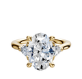 An 18K yellow gold engagement ring with a large center diamond accented by two trillion-cut side stones (0.125 TCW), showcased on a plain white background.