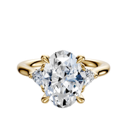 An 18K yellow gold engagement ring with a large center diamond accented by two trillion-cut side stones (0.125 TCW), showcased on a plain white background.