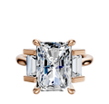 An 18K rose gold engagement ring featuring a north/south-set 0.25TCW center stone with baguette side stones in a prong setting.
