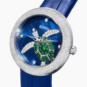 The 39MM Swiss Made Stainless Steel Turtle Watch features diamonds, sapphires, and tsavorite. It has a blue strap and dial, jeweled turtle motif in green and white stones, a diamond-encrusted silver bezel, and EFFY branding on the face.