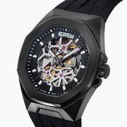 The 42MM Swiss Made Stainless Steel with Black PVD Automatic Skeleton Watch features a skeleton dial, black rubber strap, hexagonal case, and the white BEFY logo at the top against a plain white background.