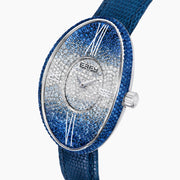 The 28MM Swiss Made Stainless Steel Cocktail Watch features a luxurious oval design with a diamond and blue sapphire-studded face, silver hands, deep blue textured leather strap, and exquisite Swiss craftsmanship.