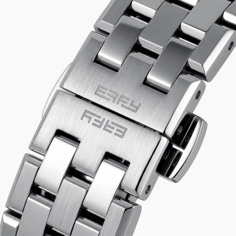 A 42MM Swiss made titanium automatic skeleton watch featuring a geometric bezel that reveals intricate gears and movements beneath the dial, complemented by a metal link bracelet.