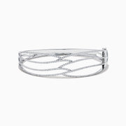 The 14K White Gold Pave Diamond Crisscross Bangle features an open, wavy design adorned with sparkling diamonds along the curves for an elegant, delicate look.