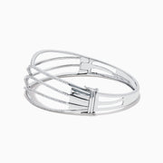 The 14K White Gold Pave Diamond Crisscross Bangle features an open, wavy design adorned with sparkling diamonds along the curves for an elegant, delicate look.