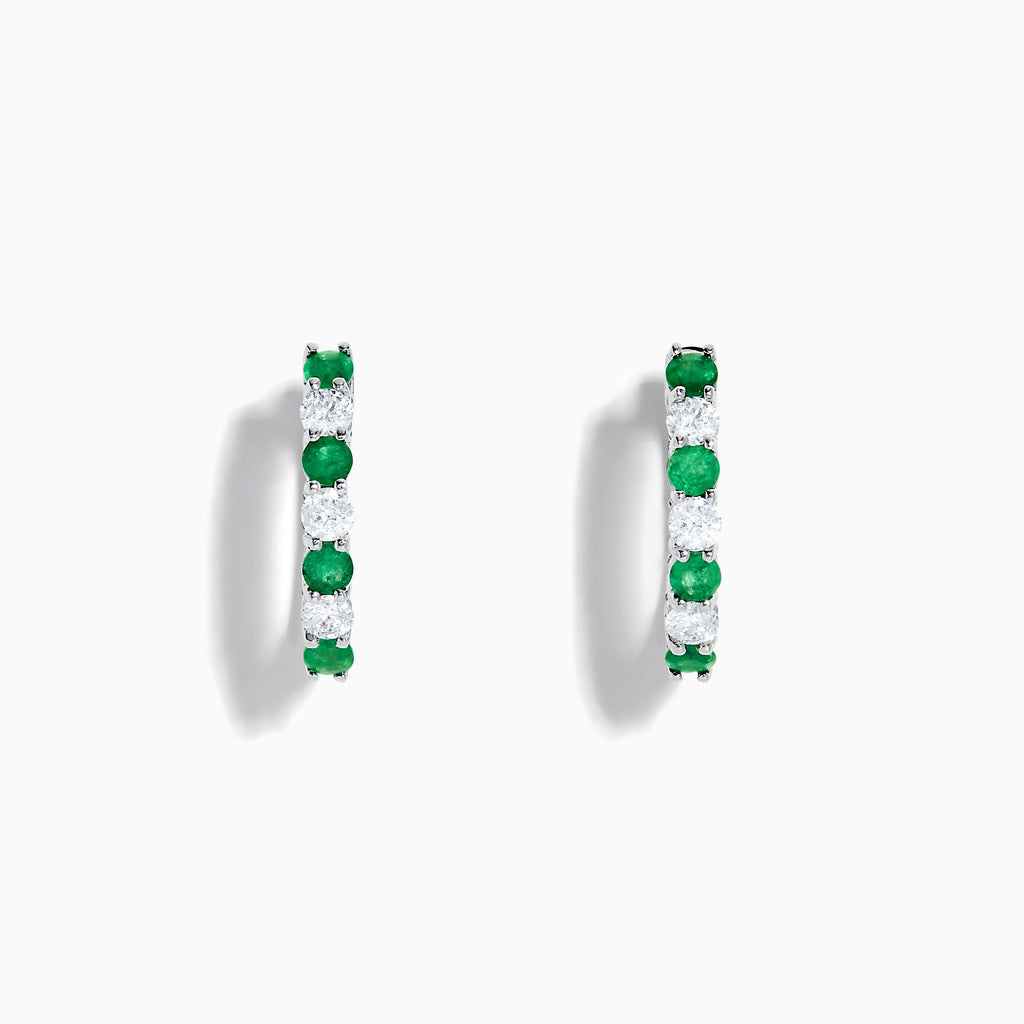 A pair of 14K white gold emerald & diamond hoop earrings, 1.10 TCW, featuring alternating green and clear gemstones set in a silver band, displayed on a white background with soft shadows.