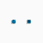 The 14K White Gold Blue Diamond Stud Earrings feature round blue diamonds set in white gold prongs, shown on a white background.