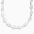 A close-up of the 14K Yellow Gold Freshwater Baroque Pearl Necklace featuring irregularly shaped white pearls and a 14K yellow gold clasp, set against a white background.