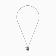 The Novelty Sterling Silver Black Diamond Cat Pendant, 0.28 TCW, features a cat design with green eyes, gold ears, a curled tail, and a body encrusted with black diamond stones.