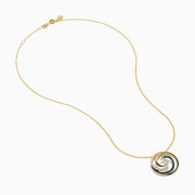 This 14 Karat Yellow Gold Blue Diamond Swirl Pendant features alternating rows of blue and clear gemstones in a spiral swirl, with an elegant wave-like design on a delicate chain.