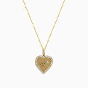 The Novelty 14k Yellow Gold Girl Mom Diamond Heart Pendant features a gold heart engraved with “Girl Mom,” a diamond-studded border, and a sparkling diamond accent above the text.