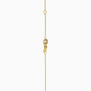 The 14K Yellow Gold Blue and White Diamond S-Curve Halo Pendant features a marquise-shaped blue and white diamond with small white stones in a symmetrical halo on a gold chain necklace.