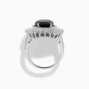 The 14K White Gold Onyx and Diamond Double Halo Ring features a large oval onyx surrounded by two rows of sparkling white diamonds, set on a white gold band and displayed against a white background.