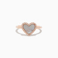 The 14K Rose Gold Mother of Pearl and Diamond Heart Ring features a heart-shaped mother-of-pearl centerpiece framed by sparkling diamonds.