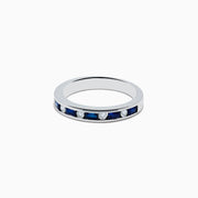 The 14K White Gold Channel-Set Blue Sapphire and Diamond Band 0.71 TCW features alternating blue sapphires and round white diamonds in a channel setting, shown against a plain white background.