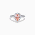 The Lab Grown Pink and White Diamond Halo Ring in 14K Two Tone Gold features a pear-shaped pink center, a halo of white diamonds, and a diamond-studded band, shown on a white background.