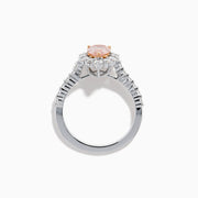 The Lab Grown Pink and White Diamond Halo Ring in 14K Two Tone Gold features a pear-shaped pink center, a halo of white diamonds, and a diamond-studded band, shown on a white background.