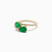 The Brasilica 14K Yellow Gold Emerald and Diamond Bypass Ring features two pear-shaped green emeralds set opposite each other on a curved band accented with sparkling diamonds.