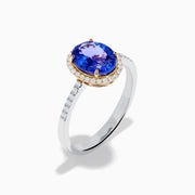 The Nahla 14K Two Tone Gold Tanzanite and Diamond Halo Ring features an oval blue tanzanite center, encircled by a diamond halo and diamond-accented band, all set in elegant two-tone 14K gold.