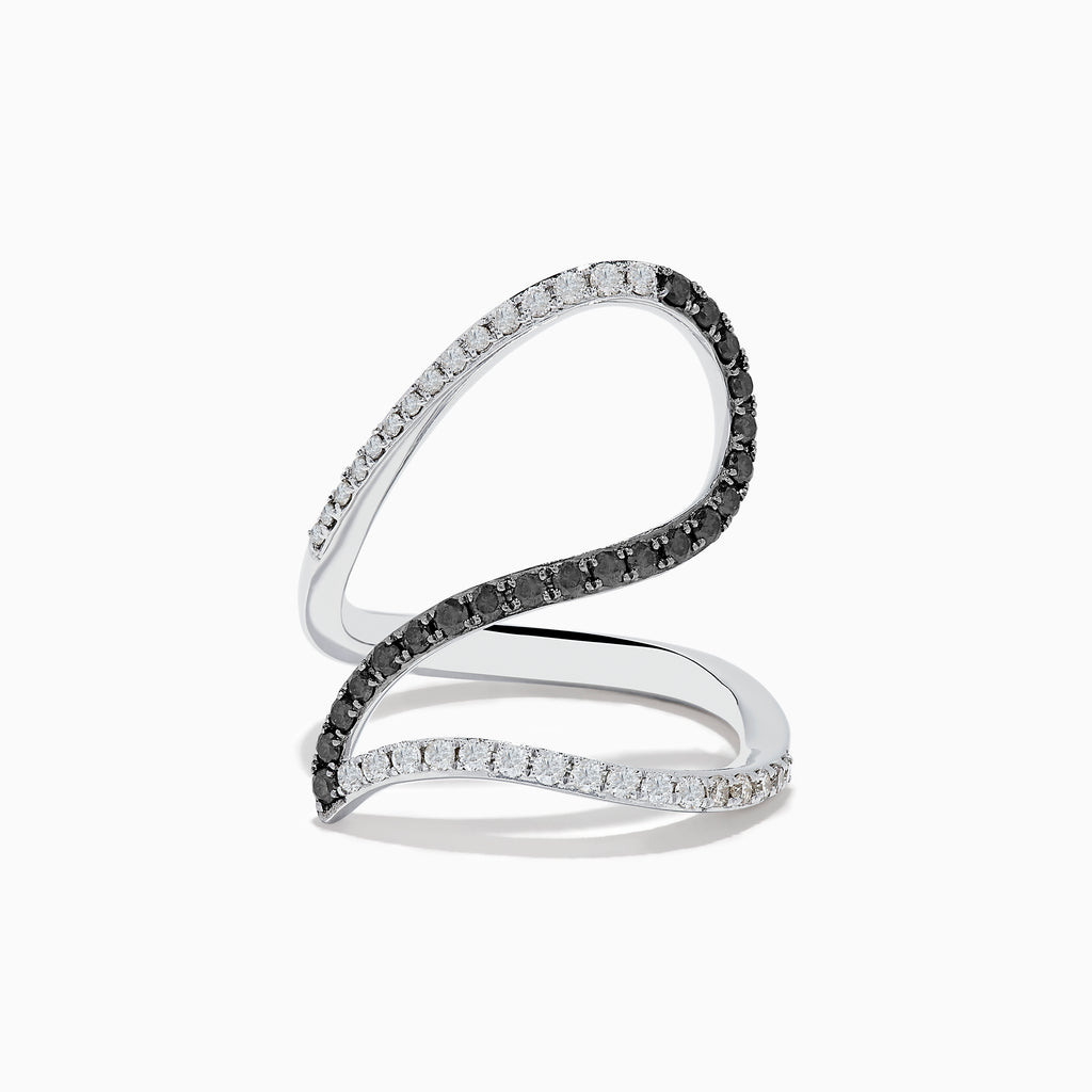 The 14K White Gold Black and White Diamond Fashion Ring features an open, wavy design with intertwined bands of sparkling white and black diamonds, creating a modern and elegant look.