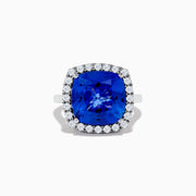 The Hematian 14K White Gold Tanzanite and Diamond Ring showcases a cushion-cut tanzanite center stone encircled by a halo of round diamonds, elegantly displayed on a white background.