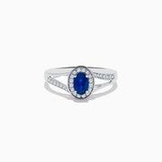 The Royale Bleu 14K White Gold Sapphire and Diamond Ring, 0.70 TCW, showcases an oval sapphire center with a diamond halo and a split shank band set with sparkling diamonds.