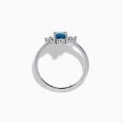 The 14K White Gold Blue and White Diamond Ring features a round blue diamond center with small white stones in a compass pattern, displayed on a white background.