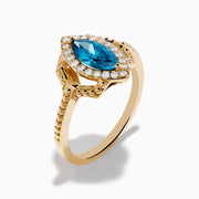 The 14K Yellow Gold Blue and White Diamond Marquise Ring features a striking blue and white diamond centerpiece, accented by a halo of round white diamonds and detailed band craftsmanship.