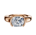 An 18K rose gold Bezel Half Bezel East/West Classic Dome 4.0mm engagement ring is shown against a white background, featuring a cushion-cut diamond set with two curved prongs on each side.