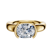 An 18K yellow gold engagement ring features a 4.0mm diamond in an East/West half bezel setting on a classic dome band, shown with the polished gold gleaming against a white background.