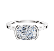 An 18K white gold cathedral engagement ring with a half bezel east/west setting and a flat 1.5mm band is shown on a plain white background.