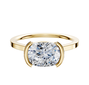 An 18K Yellow Gold Bezel Half Bezel East/West Cathedral Flat 1.5mm Engagement Ring is displayed with a large cushion-cut diamond in a modern bezel-style setting against a plain white background.