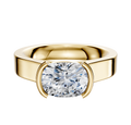 A close-up of the 18K Yellow Gold Bezel Half Bezel East/West Cathedral Flat 4.0mm Engagement Ring, showcasing its wide band and large oval diamond in a modern bezel setting.
