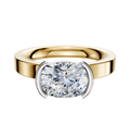 The 18K Two Tone Bezel Half Bezel East/West Classic Flat 3.0mm Engagement Ring features a wide band and cushion-cut diamond in a unique setting, showcased against a plain white background.