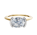 The 18K Two Tone Bezel Half Bezel East/West Cathedral Knife Edge 1.5mm Engagement Ring is displayed against a plain white background, showcasing its elegant design and craftsmanship.