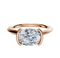 The 18K Rose Gold Bezel Half Bezel East/West Cathedral Knife Edge 2.0mm Engagement Ring features a large, round-cut diamond in a modern four-prong bezel setting, displayed on a white background.