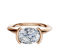 The 14K Rose Gold Bezel Half Bezel East/West Classic Knife Edge 2.0mm Engagement Ring features a large round diamond in a modern bezel with crescent prongs, shown against a simple white background.