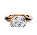The 14K Rose Gold Bezel Half Bezel East/West Classic Knife Edge 3.0mm Engagement Ring features a modern cushion-cut clear diamond in a sleek bezel setting, shown against a plain white background.