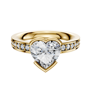 An 18K yellow gold engagement ring featuring a classic flat band with half bezel and east/west setting, accented by a single row of 2.5mm pave diamonds.
