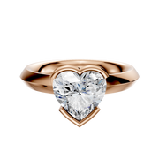 An 18K rose gold bezel half bezel east/west classic knife edge 3.0mm engagement ring is showcased against a plain white background.