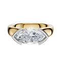 The 18K Two Tone Bezel Half Bezel East/West Cathedral Dome 4.0mm Engagement Ring features a modern, horizontally set clear gemstone in a sleek silver and gold setting, displayed against a plain white background.