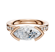 An 18K rose gold engagement ring featuring an east/west bezel-set center, a cathedral flat band, and a single row of pave diamonds along its 2.5mm width.