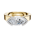 An 18K two-tone bezel half bezel East/West cathedral flat 4.0mm engagement ring featuring a wide band and a prominent center stone in an elegant mixed metal setting.