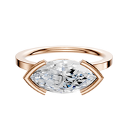 An 18K rose gold Bezel Half Bezel East/West Classic Flat 1.5mm engagement ring featuring a horizontally set marquise diamond in unique prong settings, displayed on a plain white background.