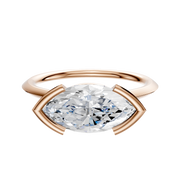 The 18K Rose Gold Bezel Half Bezel East/West Cathedral Knife Edge 1.5mm Engagement Ring is shown against a white background, featuring a modern, geometric setting in rose gold.